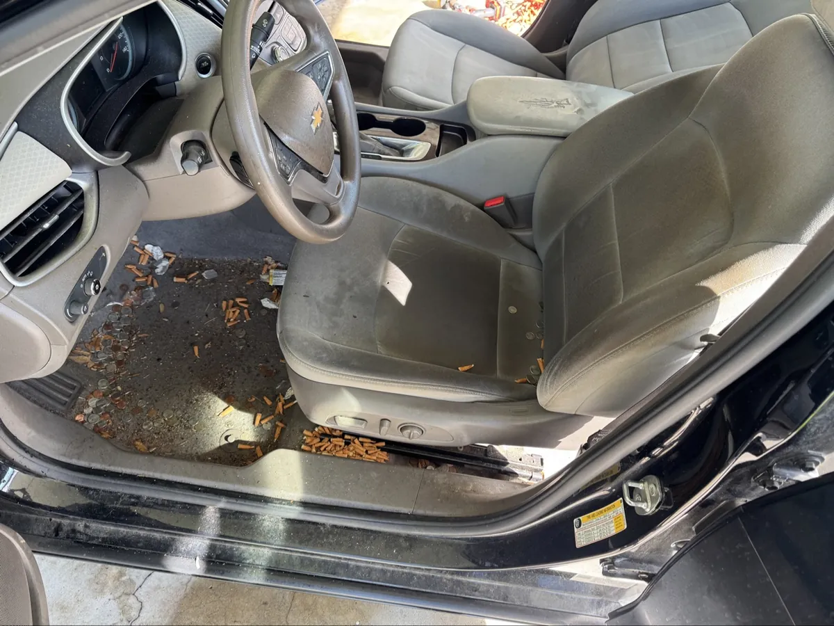Chevy interior before detailing — dirty driver seat, carpet covered in debris