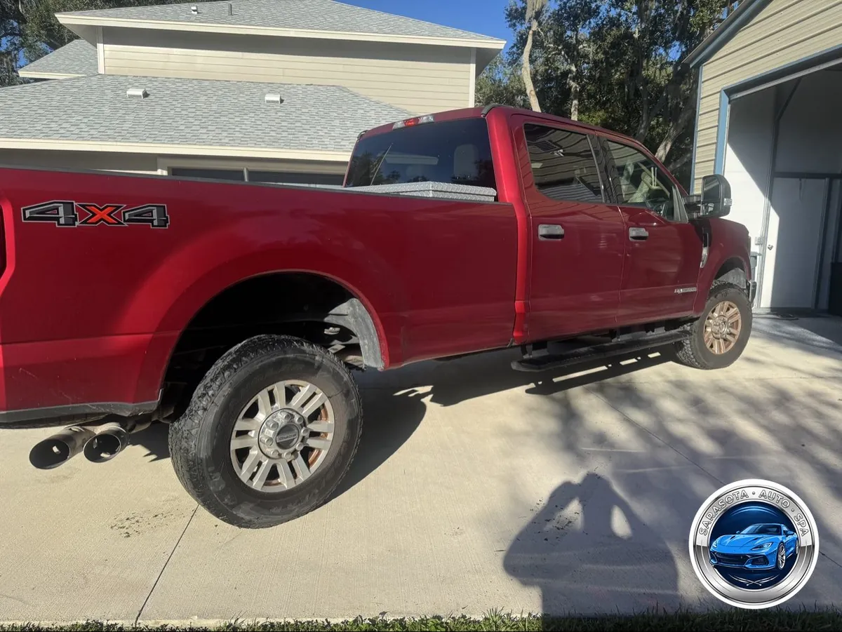 F-250 Super Duty exterior before detailing — dull red paint, wheels caked in brake dust