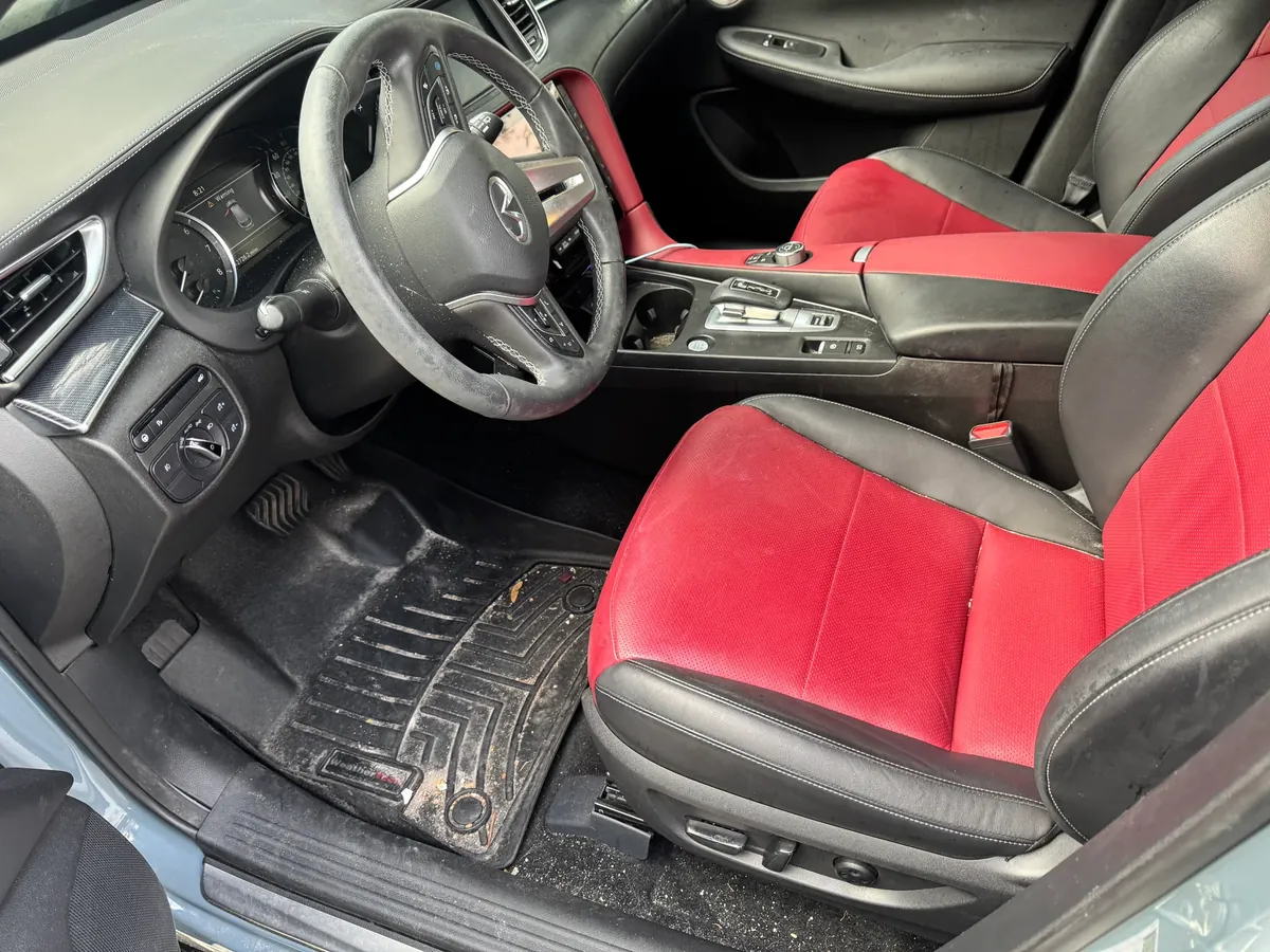 Infiniti QX50 interior before detailing — dusty dash, steering wheel and floor mat